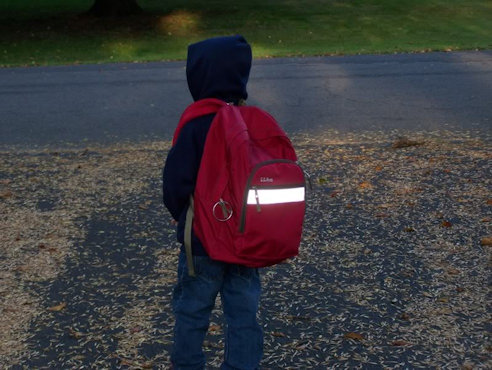 child with back turned backpack